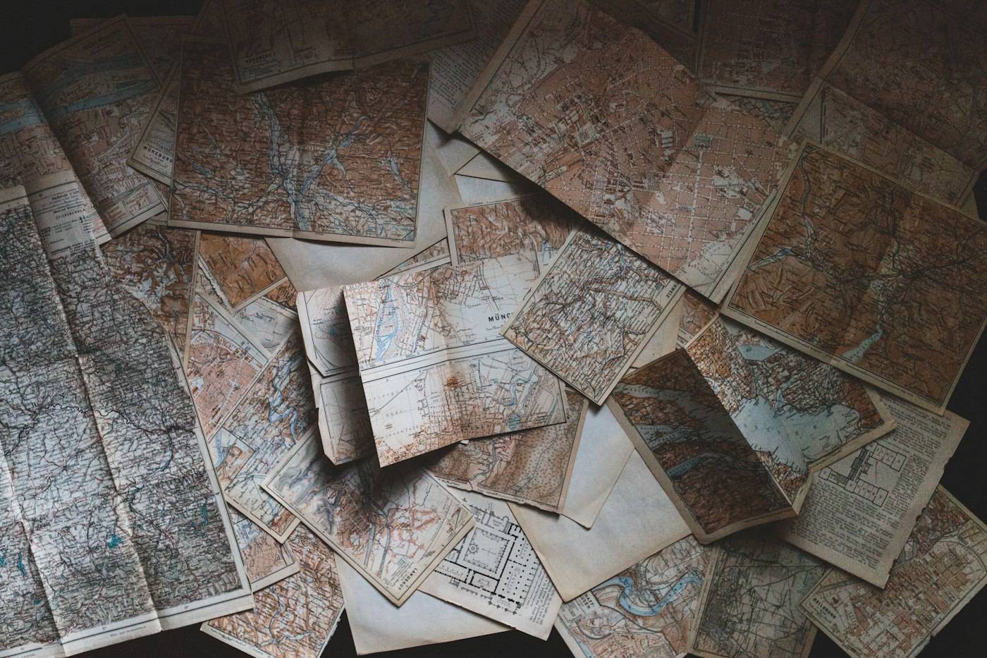 Old paper maps spread across a floor